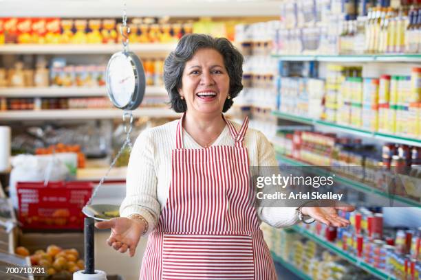portrait of welcoming hispanic grocery store owner - apron stockfoto's en -beelden