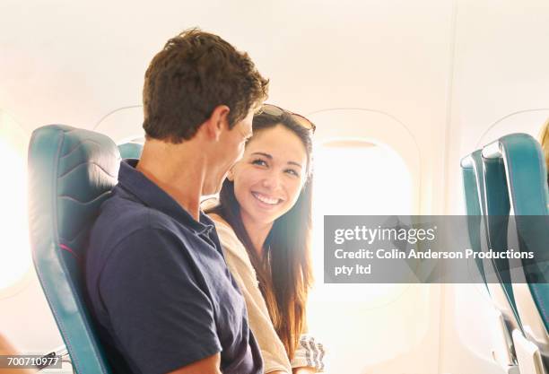 smiling couple sitting on airplane - hawaii fun fotografías e imágenes de stock