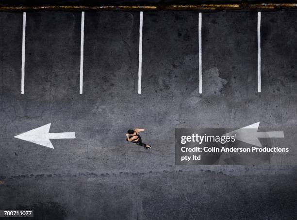 aerial view of pacific islander woman running in parking lot - car parking lot overhead stock pictures, royalty-free photos & images