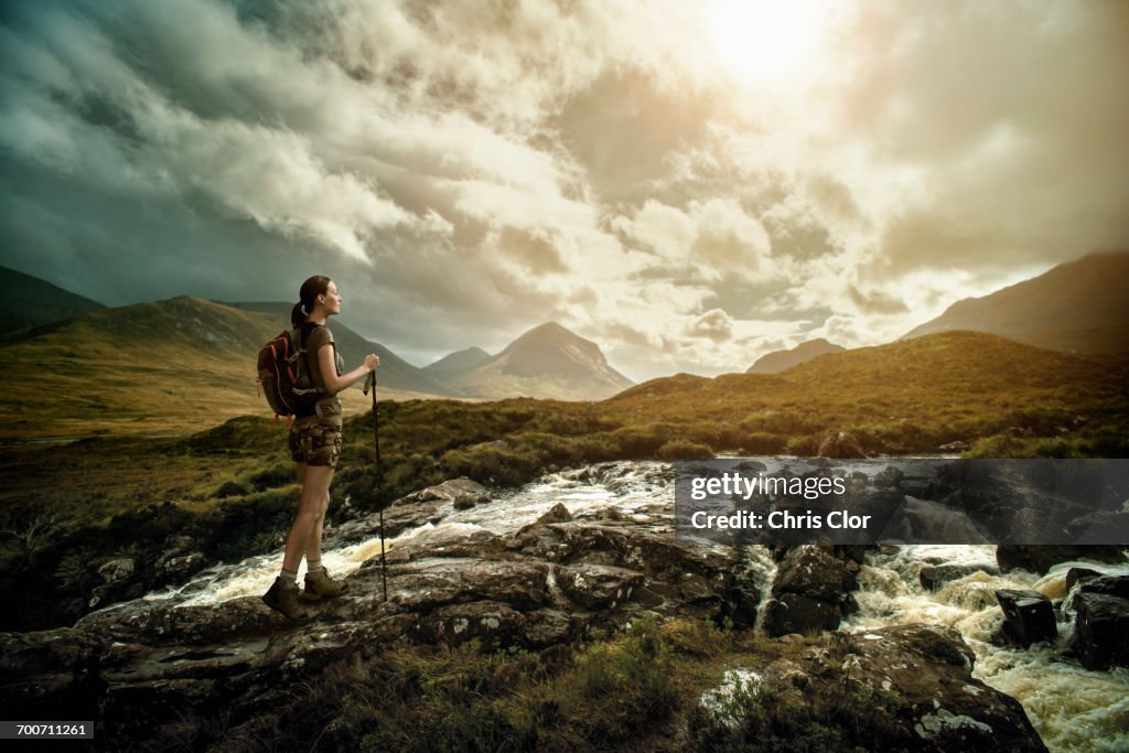 Caucasian woman hiking on rocks near river