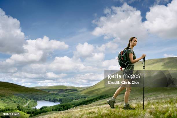 caucasian woman hiking on green hill - hiking pole stock pictures, royalty-free photos & images