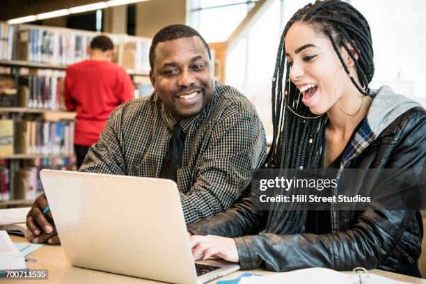 teacher and student using laptop in library - guy girl street laugh stock pictures, royalty-free photos & images