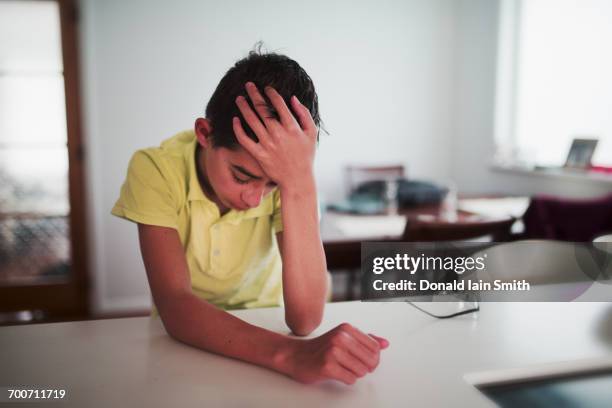 crying mixed race boy with hand on head - teen headache stock pictures, royalty-free photos & images