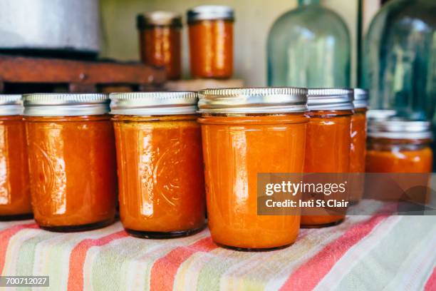 jars of peach jam on table - メイソンジャー ストックフォトと画像