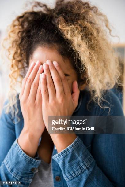 mixed race woman covering face with hands - hand covering face stock pictures, royalty-free photos & images