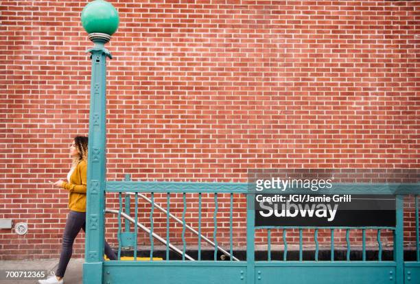 mixed race woman exiting subway station in city - brooklyn new york stockfoto's en -beelden
