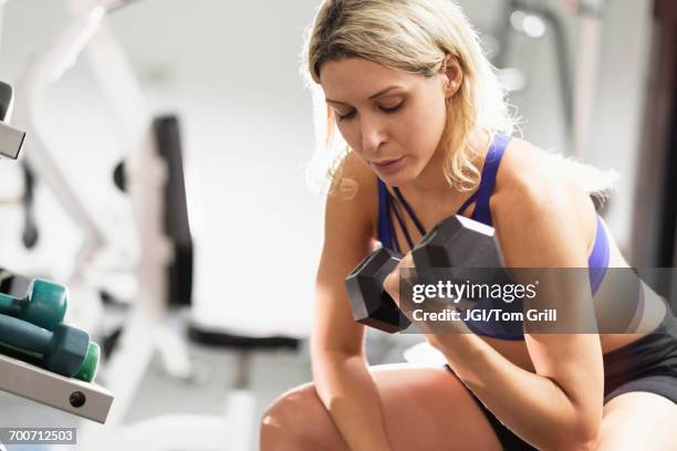 mixed race woman doing curls with dumbbell - curly hair stock pictures, royalty-free photos & images