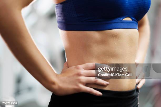 sweating midriff of mixed race woman - belly stock pictures, royalty-free photos & images