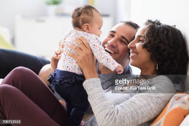 hispanic mother and father playing with baby daughter - baby father hug side stock pictures, royalty-free photos & images