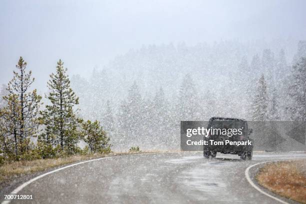 car driving on curving road in snow - car snow stock pictures, royalty-free photos & images
