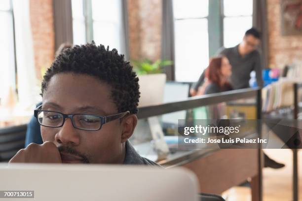 pensive businessman using computer in office - portrait of pensive young businessman wearing glasses stock-fotos und bilder