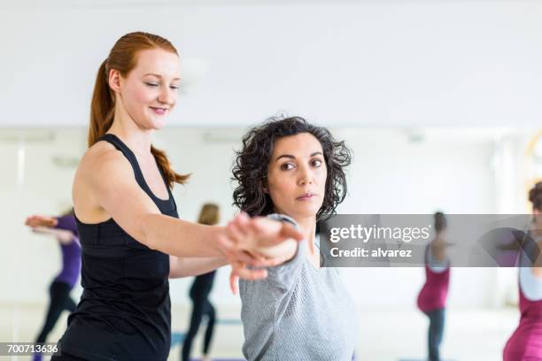 professionelle yoga-trainer unterstützt frau im health club - coach stock-fotos und bilder