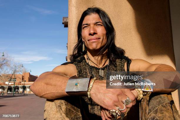 native american man sitting against post - cherokee stock-fotos und bilder