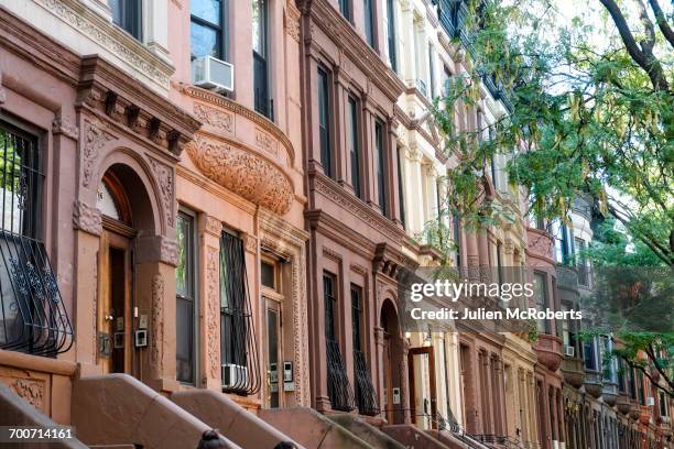 row of brownstones in city - harlem stockfoto's en -beelden