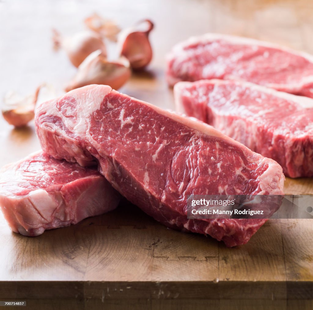 Raw steaks on wooden table