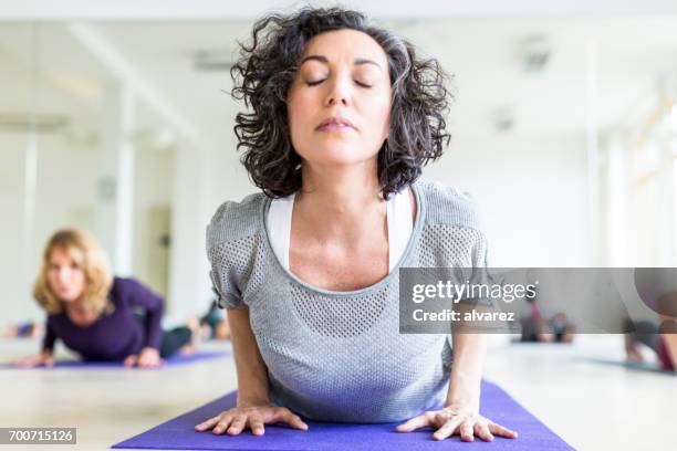 rijpe vrouwen die zich uitstrekt in het fitnesscenter - yoga germany stockfoto's en -beelden