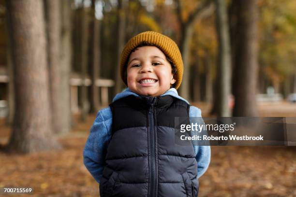 portrait of smiling mixed race boy in park - portrait winter stock pictures, royalty-free photos & images