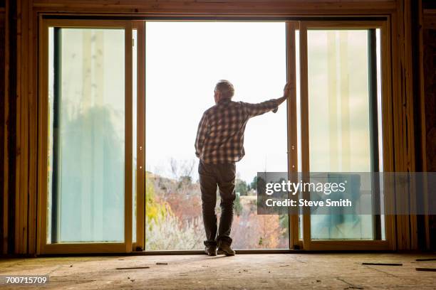 caucasian man leaning in doorway - old silhouette man stockfoto's en -beelden