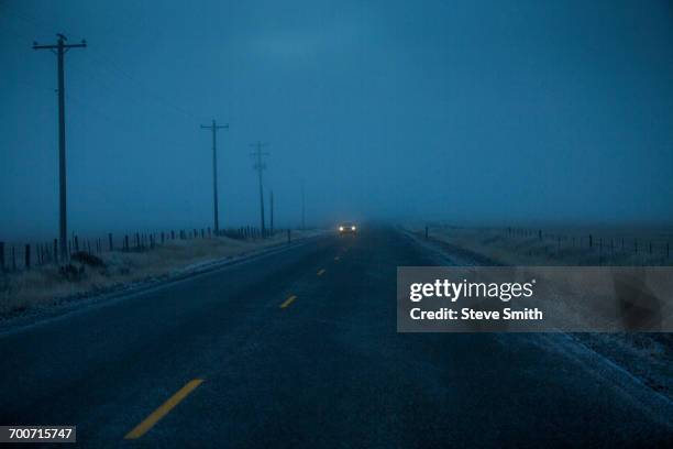 car approaching on icy two-lane road - car country road photos et images de collection