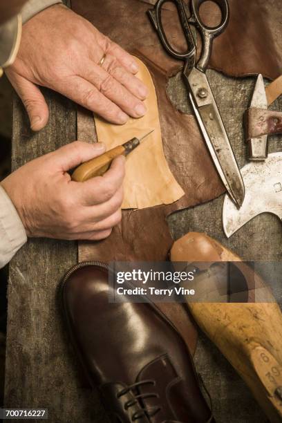 hands of shoemaker using awl on leather - calzature di pelle foto e immagini stock