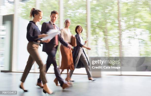 business people walking on the move in office lobby - soft focus office stock pictures, royalty-free photos & images