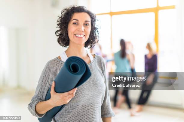 glücklich reife frau mit einer yogamatte im health club - mat stock-fotos und bilder