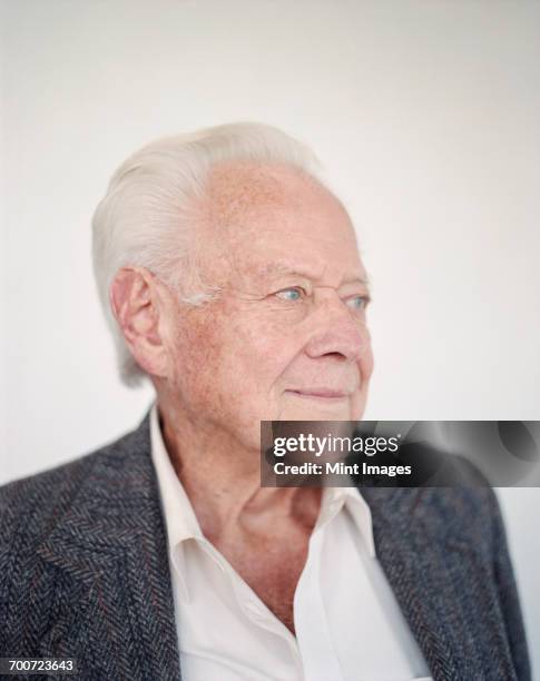 a man with grey hair looking away, dressed in an open necked shirt with a grey jacket. - both eyes open looking away bildbanksfoton och bilder