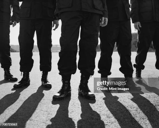 low angle view of row of men wearing military uniforms, casting shadows - special forces stockfoto's en -beelden