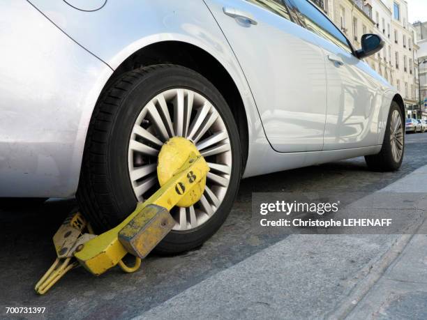 france, paris. 8th district. wheel clamp impeding parked car on a bus/taxis lane - clamp stock pictures, royalty-free photos & images