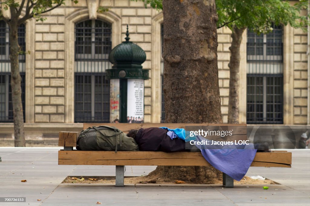France, Paris, 3rd district, Place de la Republique, homeless man lying on a bench, August 2014.