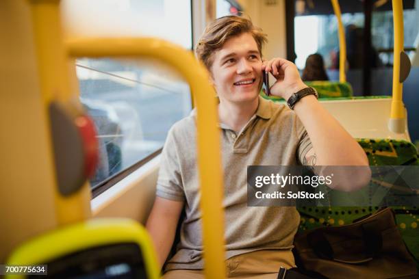 young man using smartphone on the tram - melbourne train stock pictures, royalty-free photos & images