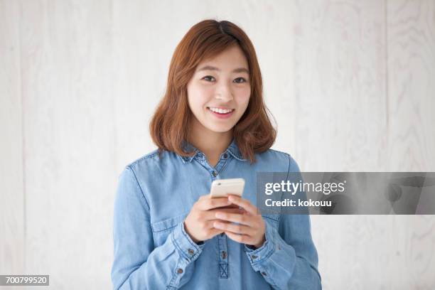 woman with a smartphone - woman fingers in ears stock pictures, royalty-free photos & images