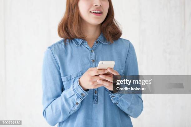 woman with a smartphone - woman fingers in ears stock pictures, royalty-free photos & images