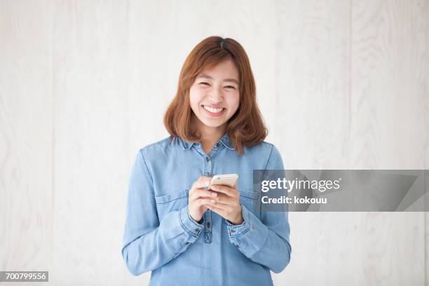 mujer con un smartphone - woman fingers in ears fotografías e imágenes de stock