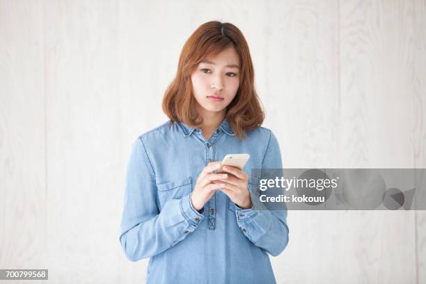 mujer con un smartphone - woman fingers in ears fotografías e imágenes de stock