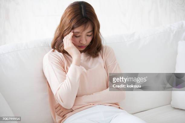 mulher sentada em um sofá - condição médica - fotografias e filmes do acervo