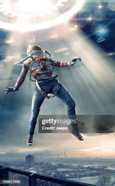 young man in spacesuit levitating in light towards ufo - ufo abduction stock pictures, royalty-free photos & images