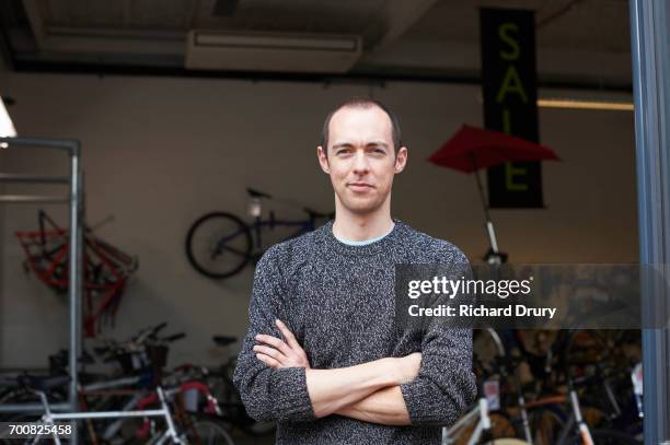 portrait of bicycle mechanic in shop - smirk stock pictures, royalty-free photos & images