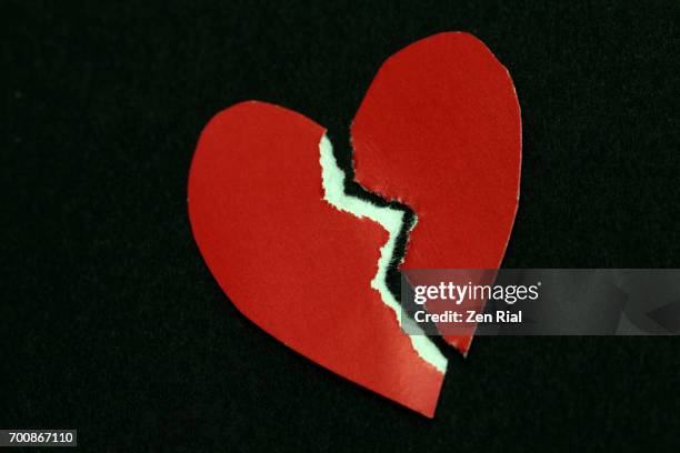 torn heart shaped paper on black background - brustet hjärta bildbanksfoton och bilder