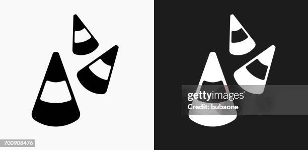 halloween candy corn icon on black and white vector backgrounds - candy corn stock illustrations