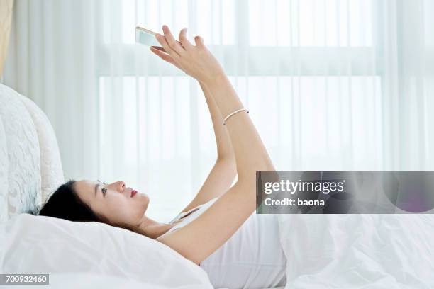 woman using a digital tablet in bed - duvet inners stock pictures, royalty-free photos & images