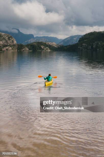 woman kayaking on the lake in norway - puddling stock pictures, royalty-free photos & images