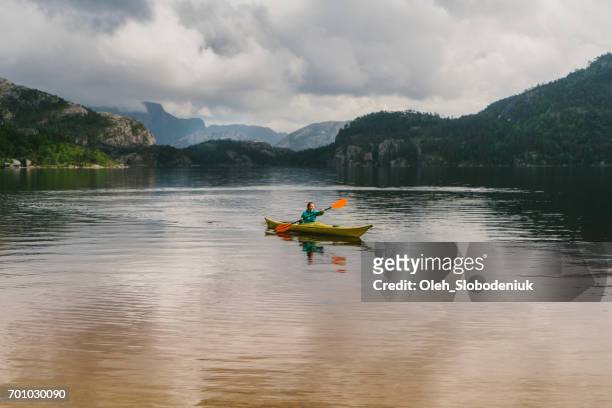 vrouw kajakken op het meer in noorwegen - puddling stockfoto's en -beelden