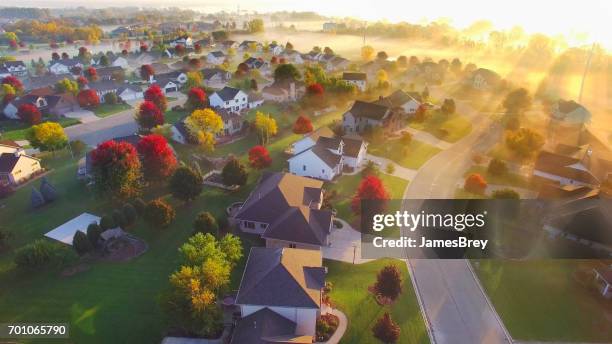 spectacular sunbeams through fog in autumn neighborhood, aerial view. - wisconsin house stock pictures, royalty-free photos & images