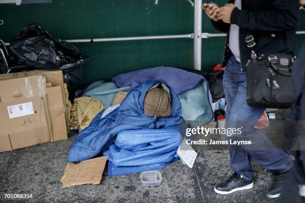 a homeless person sleeps on the street in new york - homeless person stockfoto's en -beelden