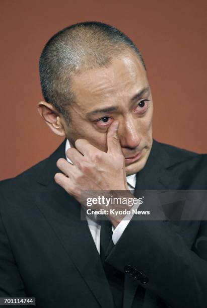 Japanese kabuki star Ichikawa Ebizo wipes away tears during a press conference in Tokyo on June 23 after his wife Mao Kobayashi, a 34-year-old...