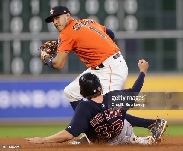 Carlos Correa of the Houston Astros looks to turn a double play as Josh Rutledge of the Boston Red Sox slides into second base at Minute Maid Park on...