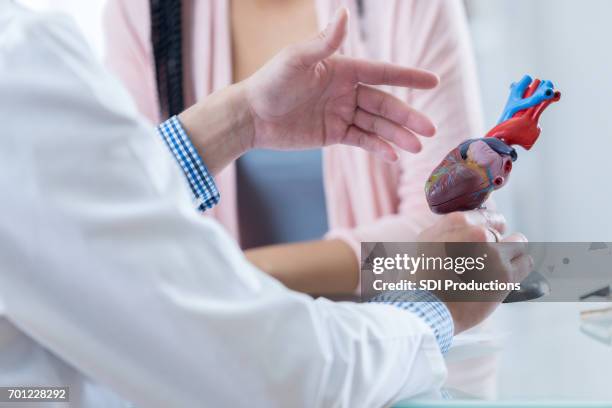 male cardiologist discusses diagnosis with patient - cardíaco imagens e fotografias de stock