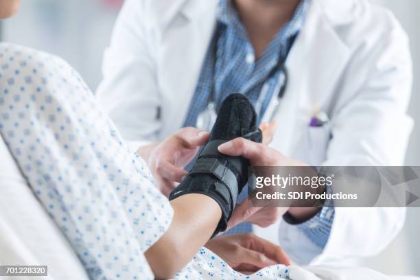 profesional de la salud lugares de apoyo en el brazo del paciente - physical injury fotografías e imágenes de stock