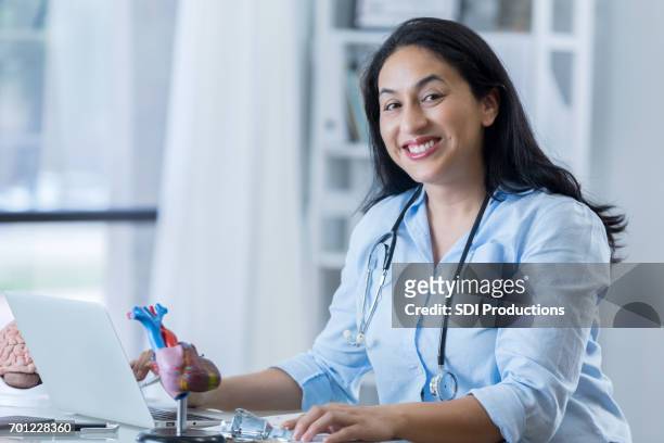 confident female cardiologist at work - cardiologist portrait stock pictures, royalty-free photos & images